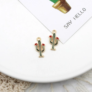 Detailed view of green enamel cactus pendants with red flower accents for DIY jewelry making