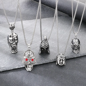 Detail view of five gothic stainless steel pendants featuring skulls and a Buddha head.