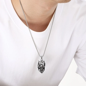 Detailed close-up showing a gothic Viking skull helmet pendant in stainless steel on a male model