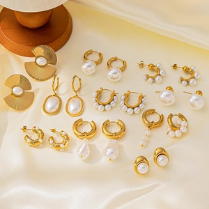 Collection de boucles d'oreilles perles dorées avec divers anneaux et puces sur soie