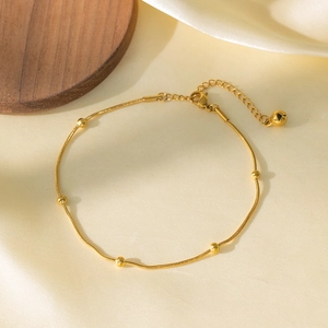 Bracelet minimaliste à perles dorées et chaîne serpent sur fond de soie douce
