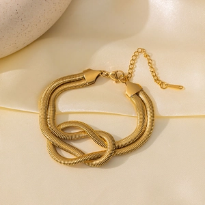 Bracelet double chaîne serpent dorée avec un design de nœud central sur du satin soyeux
