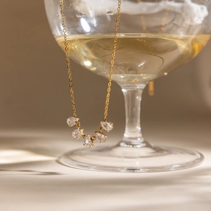 Detailed close-up of an 18K gold-plated necklace with five teardrop-shaped zircons.
