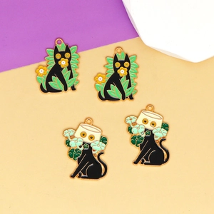 Close-up detail of four black cat enamel charms with botanical elements for DIY jewelry