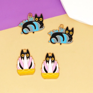 Close-up of cute black cat and plant enamel charms for DIY jewelry making
