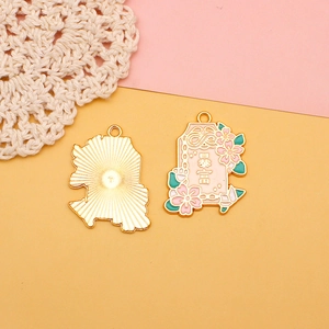 Detailansicht eines rosa Kirschblüten-Emaille-Omamori-Anhängers mit vergoldeter Rückseite