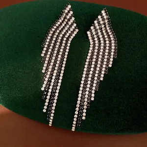 Vintage silver needle tassel earrings with black and white rhinestones on green velvet