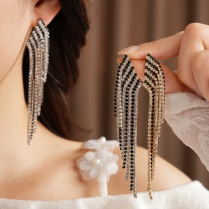 Detailed macro view of long vintage tassel earrings with black and white rhinestones