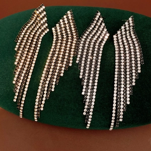 Macro detail of luxury silver needle fringe earrings with black and white rhinestones.