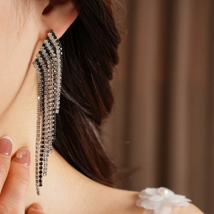 Exquisite vintage style black and clear rhinestone long tassel earrings worn on ear