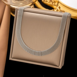 Silbernes gewebtes Gliederarmband aus Titanstahl auf einem beigen Schmuckständer