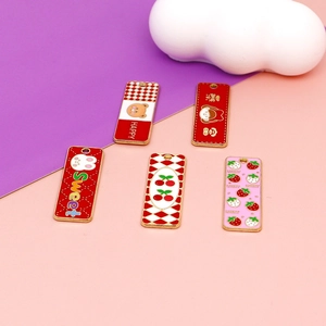 Vue macro de divers breloques en émail coloré avec des motifs de fraise et de lapin
