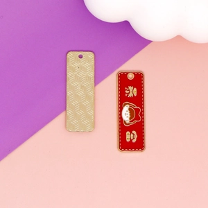 Détail d'un pendentif lapin fraise en émail rouge avec dos doré texturé pour bijoux DIY