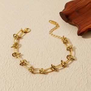 Macro detail of 18K gold-plated necklace featuring unique knotted links and K18 hallmark tag