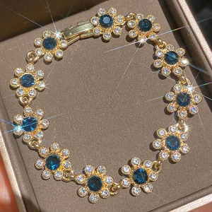 Luxuriöses vergoldetes Blumenarmband mit funkelnden blauen und klaren Zirkonia-Steinen