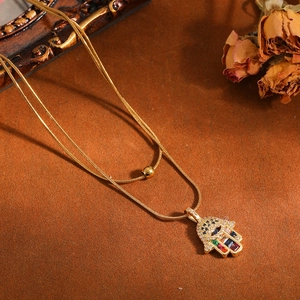 Gedetailleerd overzicht van Hamsa-handhangerketting met kleurrijke stenen en boze oog