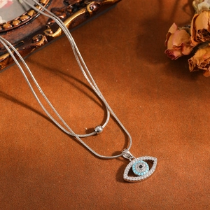 Gedetailleerde macro-opname van zilveren evil eye hanger met lichtblauwe turkoois inleg