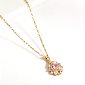 Nahaufnahme einer eleganten Goldkette mit einem brillanten rosa Edelsteinanhänger