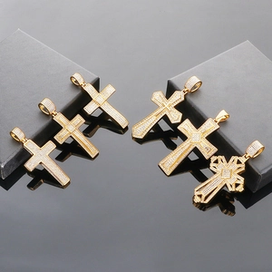 Close-up of five gold-plated hip hop cross pendants with sparkling white zircons on black display