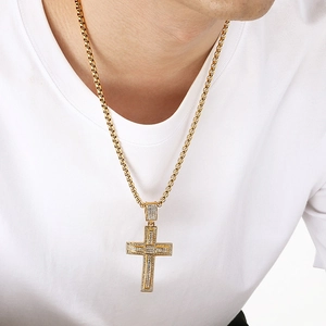 Close-up of a gold double-layer cross pendant with sparkling diamonds on a box chain