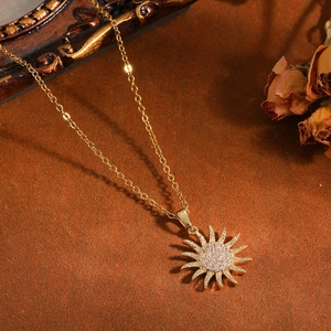 Primo piano di un elegante collana con ciondolo a sole dorato e zirconi lucenti.