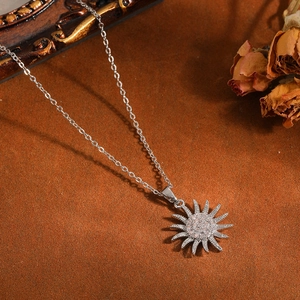 Dettaglio della collana con pendente a raggio di sole in argento con strass lucenti.