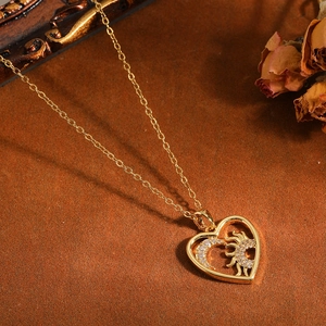 Macro dettagliata di una collana con ciondolo a cuore con motivi sole e luna in oro lucido