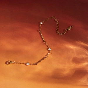 Close-up of gold stainless steel bracelet with zircons and S.steel engraved tag