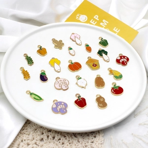 Enamel vegetable and fruit alloy charms for DIY jewelry making displayed on a plate.
