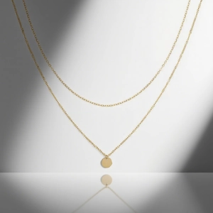 Minimalist double layer stainless steel necklace with a round golden pendant on grey background