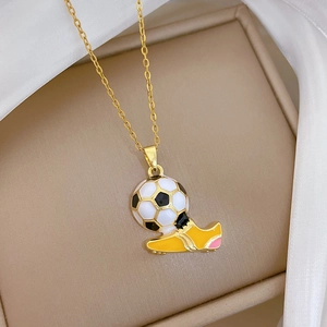 Primo piano di una collana dorata con ciondolo a pallone da calcio e scarpa gialla