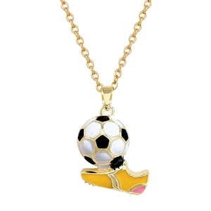 Dettaglio macro del ciondolo a forma di pallone da calcio e scarpa gialla su catena d'oro