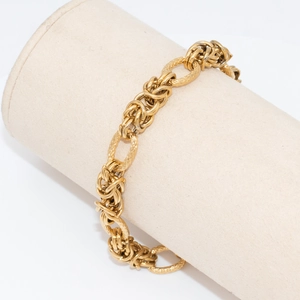 Retro golden chunky chain bracelet with woven Byzantine style links on a display stand