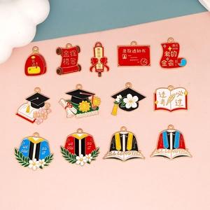 Selection of enamel graduation charms featuring academic caps and scrolls for DIY crafts.