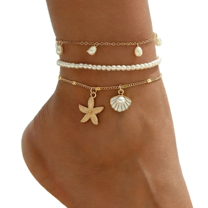 Elegante juego de tobilleras en capas con estrella de mar dorada y perlas