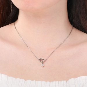 Vista dettagliata di una collana a nodo d'argento con ciondolo di perla sul collo modella