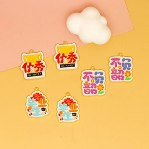 Macro detail of alloy drip oil charms with graduation and success themes in vibrant colors