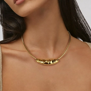 Close-up of a gold-plated stainless steel choker with a textured pendant on a model