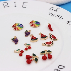 Close-up of colorful enamel fruit charms including watermelon and cherry for DIY jewelry