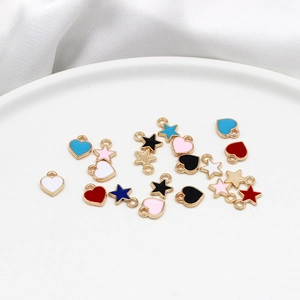 Macro view of colorful alloy heart and star charms with golden borders for DIY jewelry