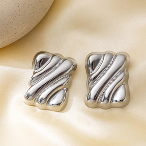Polished silver square earrings with wavy texture on elegant yellow silk background