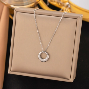 Silver minimalist ring pendant necklace displayed on a luxury champagne gift box