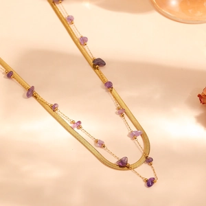 Close-up of double-layered gold anklet with flat snake chain and purple amethyst chips