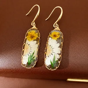 Elegant handmade resin oval drop earrings with yellow and white dried flowers