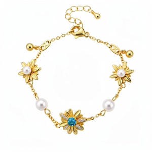 Squisito bracciale floreale vintage placcato oro con perle bianche e zircone blu centrale