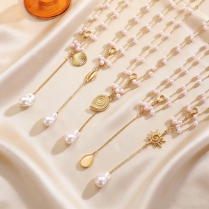 Exquisite detail of multilayer gold body chains featuring pink pearls and seashell charms