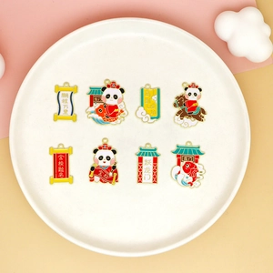 Detail of cute panda enamel charms with Chinese lucky motifs on white plate