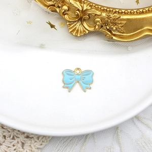 Primo piano di ciondolo a fiocco in smalto azzurro con elegante finitura in lega dorata