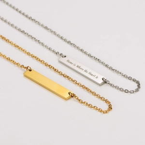 Detalle de los collares de barra dorados y plateados con grabado Home is Where the Heart Is
