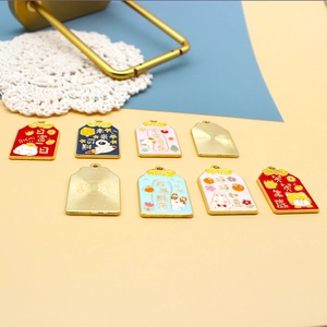 Detailansicht bunter Omamori-Anhänger aus Legierung mit Glückssprüchen und Zeichentrickfiguren